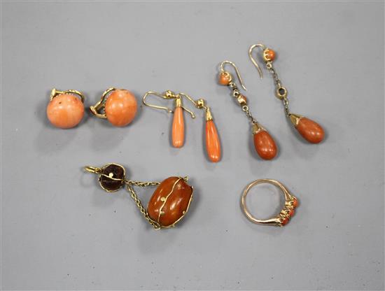 Tow pairs of yellow metal and coral drop earrings, a pair of coral ear clips, a three stone coral ring and an amber set pendant.